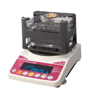 Alfa Mirage GKS-300 precious metal tester weighing a gold chain and jewelry.