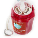 Hand using the dip tray to clean silver jewelry inside the Connoisseurs Silver Jewelry Cleaner jar.