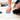 A woodworker handsanding a narrow wood strip with a folded sheet of blue Matador sandpaper