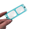 Hand holding a blue Optivisor replacement optical glass lens plate number 7.