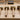 Four different sizes of rawhide mallets lined up on a wooden jewelry-making workbench.