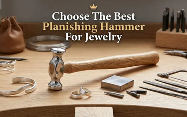 A jewelry planishing hammer on a workbench surrounded by silver bracelets, rings, and metalsmithing tools.