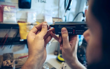 Jeweler using an electronic diamond tester tool to inspect a diamond gemstone ring