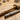 Rawhide mallet and steel ring sizer mandrel lying on a wooden jewelry-making workbench.