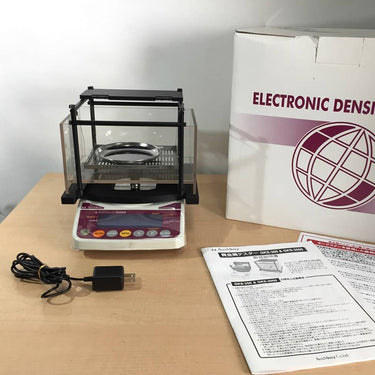 Alfa Mirage GKS-3000 gold tester kit with power adapter, manual, and packaging box.