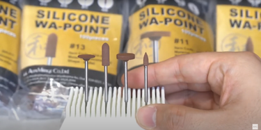 Front view of four brown Alfa Mirage Silicone WA-Points held in a white stand against product packaging.