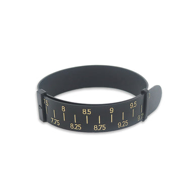 A black plastic bracelet sizer gauge looped together with gold-colored measurement markings on a white background.