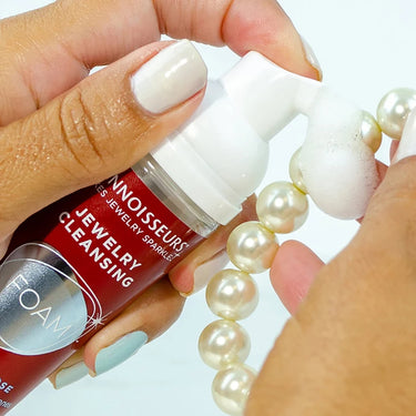 Close-up of applying Connoisseurs cleansing foam directly to a pearl necklace.