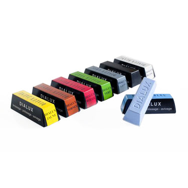 A diagonal line of Dialux polishing compound bars with one blue bar resting in front.