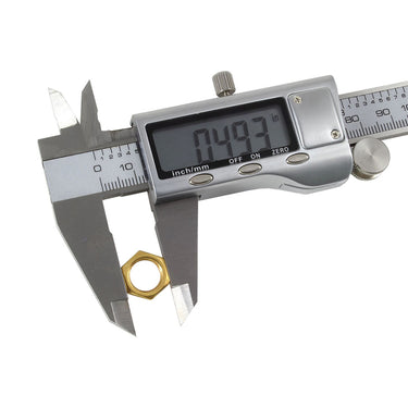 Close-up of digital display stainless steel caliper measuring the outer diameter of a brass hex nut.