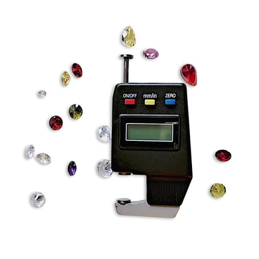 An electronic jewelry gem gauge surrounded by various colorful faceted loose gemstones.