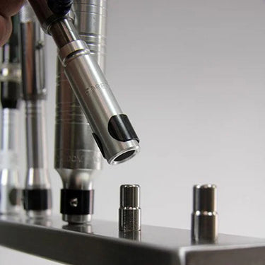 Close-up of placing a Foredom flex shaft handpiece onto the multi handpiece arm peg.