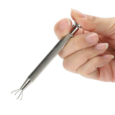 Hand pressing spring plunger of TSK gem holder tool to extend 4 steel wire pickup prongs.
