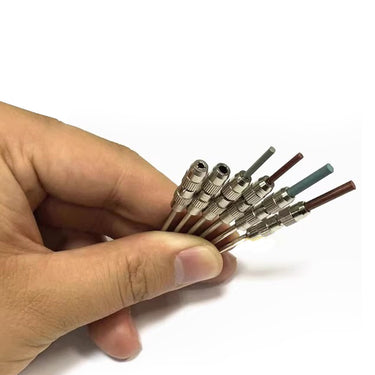 Hand holding a fan of polishing pin mandrels chucked with various multi-colored rubber abrasive pins