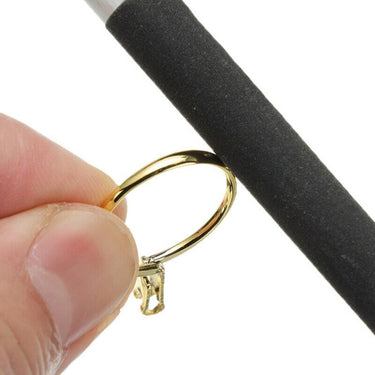 Close up of a jeweler holding a gold ring and polishing the surface with an abrasive sanding stick
