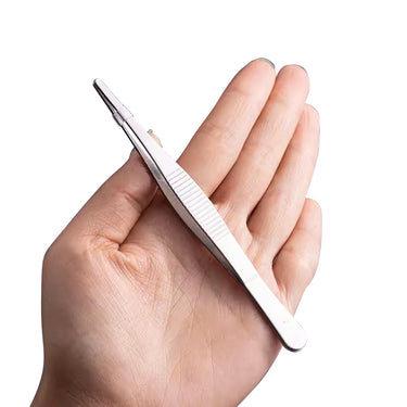 Hand holding a long straight stainless steel industrial tweezer with wide ribbed finger rest.