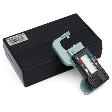 A digital thickness gauge caliper resting next to its closed black plastic storage case.