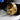 Perspective view of a finger ring held by a brass rotary fixture inside the jewelry engraving machine