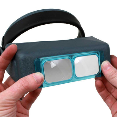 Demonstrating how to install a blue replacement lens plate onto an Optivisor headband.