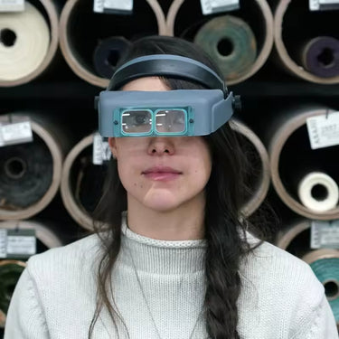 A woman wearing the Optivisor headband magnifier for precision work.