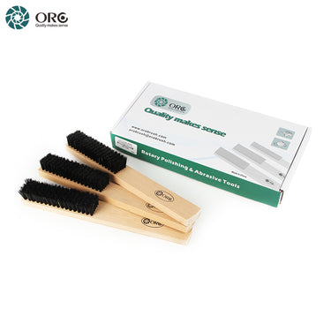 ORO black bristle wooden handle brushes stacked next to their white and green retail packaging box.