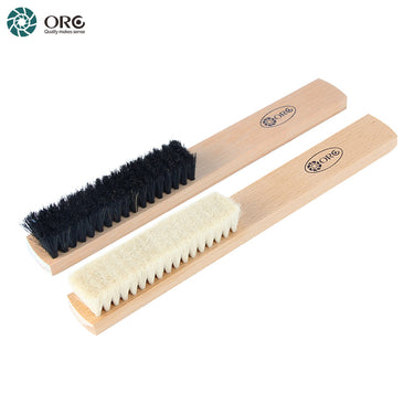 Close-up diagonal view of ORO white goat hair and black bristle dental lab polishing brushes.