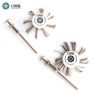 An overhead view of two ORO MediMat satin texture brush wheels and two metal mandrels separated diagonally.
