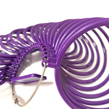 Close-up of size number markings stamped on a purple plastic bangle measuring loop set.