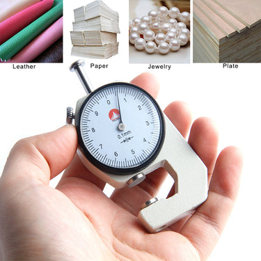 A hand holding the mechanical dial gauge below sample images of compatible materials like leather, paper, and jewelry.