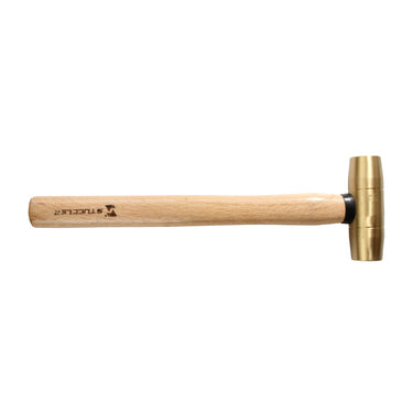 Side view of a Stuccler brass mallet lying horizontally with the cylindrical metal head facing right.
