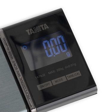 Close-up of Tanita 1479J2 blue backlit LCD display showing 0.00g and 0.01g graduation.