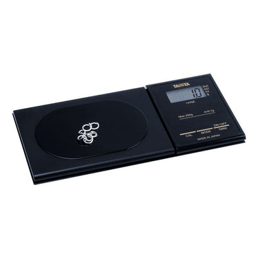 Tanita 1479Z pocket scale weighing silver jewelry pieces on its black platform.
