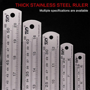 Row of five thick stainless steel rulers standing vertically to showcase different size specifications.