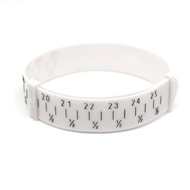 Close-up of a white plastic bangle sizer buckled into a loop showing numbers and half-size fractions.