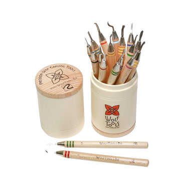 Open canister of Wolf wax carvers with two tools lying on a white surface.