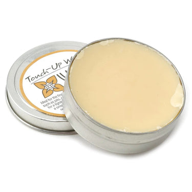 Close-up view of the pale yellow Wolf's Touch-Up Wax inside an open metal tin.